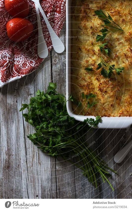 Käsegericht mit Kräutern Speise Kraut Tomate Petersilie Pfanne gebraten Tisch rustikal Serviette hölzern Mahlzeit Lebensmittel Küche lecker geschmackvoll