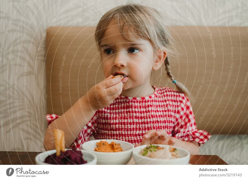 Mädchen isst mit handverlesenem Essen am Tisch Schalen & Schüsseln Feinschmecker selbstgemacht organisch Ernährung geschmackvoll erfrischend roh bezaubernd