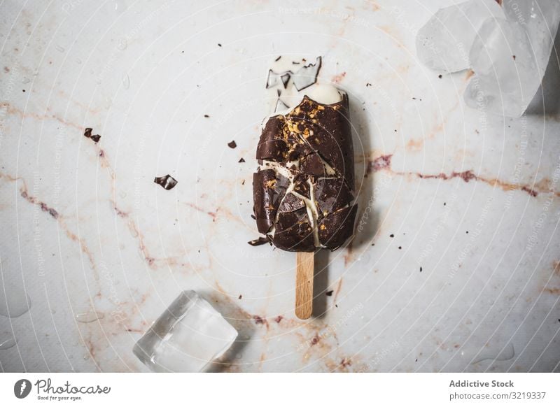 Zerkleinertes Schokoladen- und Vanille-Eis am Stiel Speiseeis Mandel Sahne Hintergrund Sommer Dessert lecker kleben Lebensmittel braun süß kalt geschmackvoll