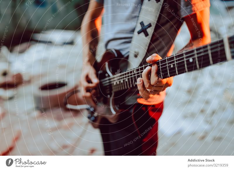 Mann spannt Saiten am Gitarrenhals ein Musiker elektrisch Hals Schnur Verschluss Leistung Griffbrett Instrument Entertainment spielen männlich Klang Felsen live