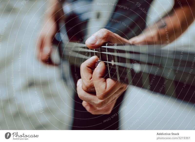 Mann spannt Saiten am Gitarrenhals ein Musiker elektrisch Hals Schnur Verschluss Leistung Griffbrett Instrument Entertainment spielen männlich Klang Felsen live