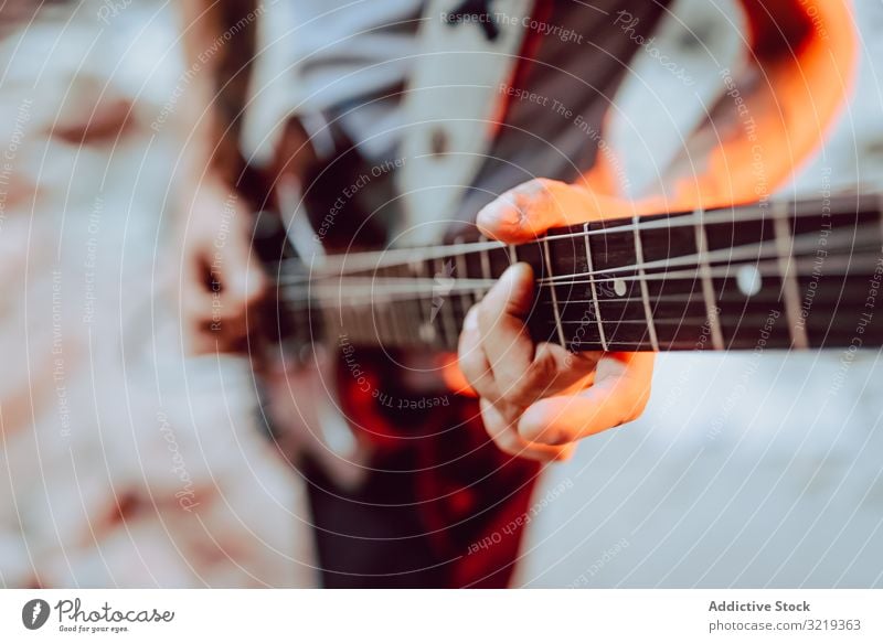 Mann spannt Saiten am Gitarrenhals ein Musiker elektrisch Hals Schnur Verschluss Leistung Griffbrett Instrument Entertainment spielen männlich Klang Felsen live