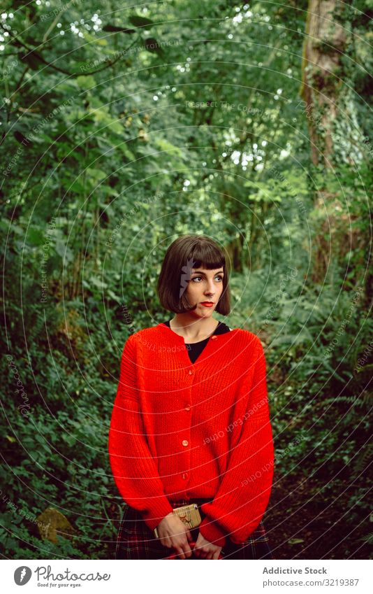 Frau in Rot mit großem roten Koffer im Wald reisen stylisch grün Piercing Gepäck Natur schön Tasche Freiheit allein Ausflug Reise Buchse Baum Tourist elegant