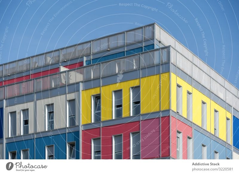 Fassade eines modernen mehrfarbigen Gebäudes mit schmalen Fenstern Außenseite farbenfroh Architektur Haus Anwesen Konstruktion Investition wohnbedingt Struktur