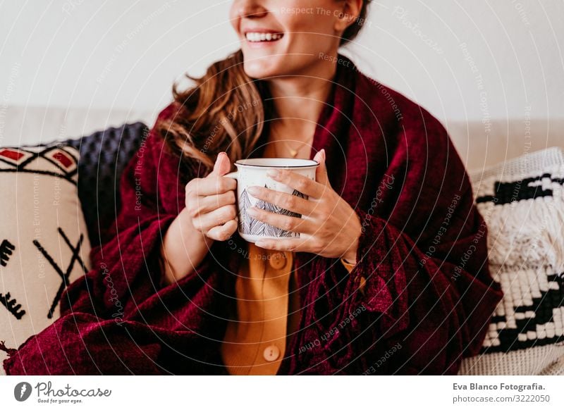 Schöne Frau auf dem Sofa sitzend, eine Tasse Tee genießend. Lebensstil im Haus, Herbstsaison Kaffee heimwärts Morgen Kaukasier Lifestyle Innenaufnahme Frühstück