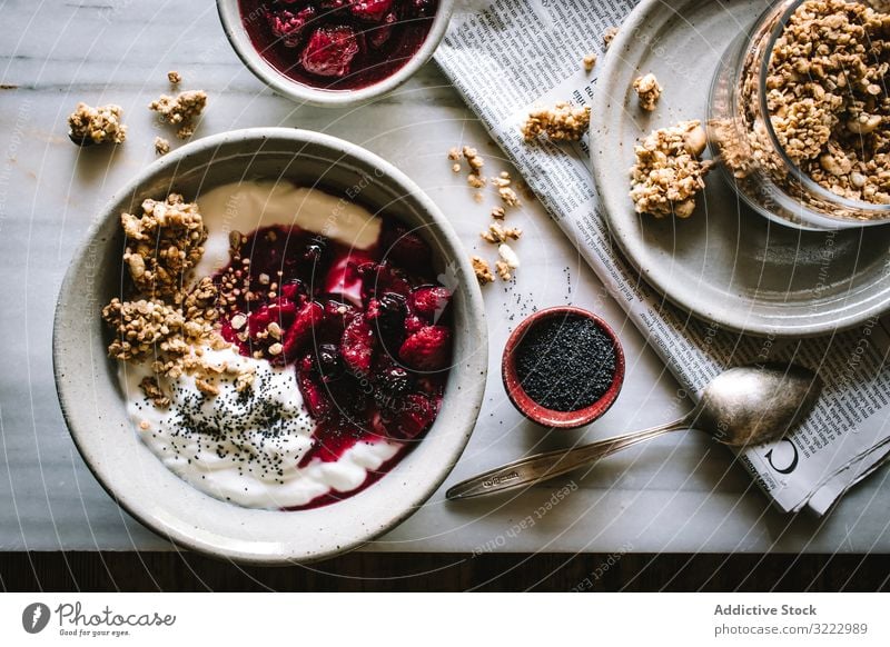 Leckere Frühstücksschüssel mit Quinoa, Reis und Grütze in der Nähe von Teetasse und Zeitung Schalen & Schüsseln Lebensmittel Morgen Beeren Chia Samen Diät