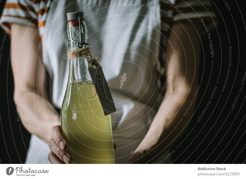 Weiblich mit Flasche Holunderblütensirup Frau Sirup Glas selbstgemacht Getränk trinken Erfrischung lässig ernst gestreift T-Shirt Schürze stehen Frucht