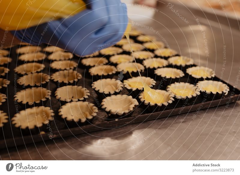 Erntebäcker, der Teig auf einem Blech auspresst Konditor Bäckerei Teigwaren drücken Tablett Keks Arbeit Küche Vorbereitung professionell Lebensmittel Papier