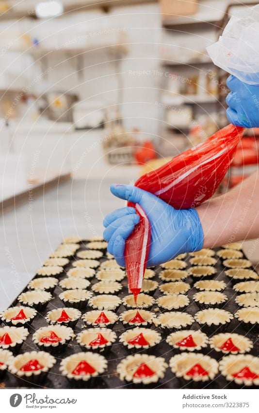 Getreidebäcker, der Gebäckbehälter mit Gelee füllt Konditor Bäckerei Götterspeise drücken Torte Tasche Fall Küche süß Lebensmittel Dessert kulinarisch