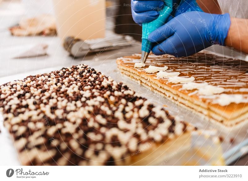 Erntebäcker, der Teig auf einem Blech auspresst Konditor Bäckerei Teigwaren drücken Tablett Keks Arbeit Küche Vorbereitung professionell Lebensmittel Papier