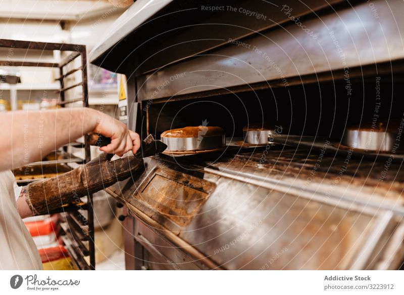 Kahlköpfiger Bäcker prüft Gebäck im Ofen Mann Bäckerei schauen Sie Arbeit Konditor prüfen Koch heiß Prozess männlich Erwachsener Uniform Küche Kleinunternehmen