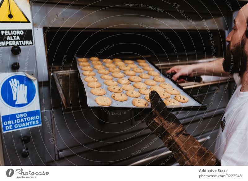 Kahlköpfiger Bäcker prüft Gebäck im Ofen Mann Bäckerei schauen Sie Arbeit Konditor prüfen Koch heiß Prozess männlich Erwachsener Uniform Küche Kleinunternehmen