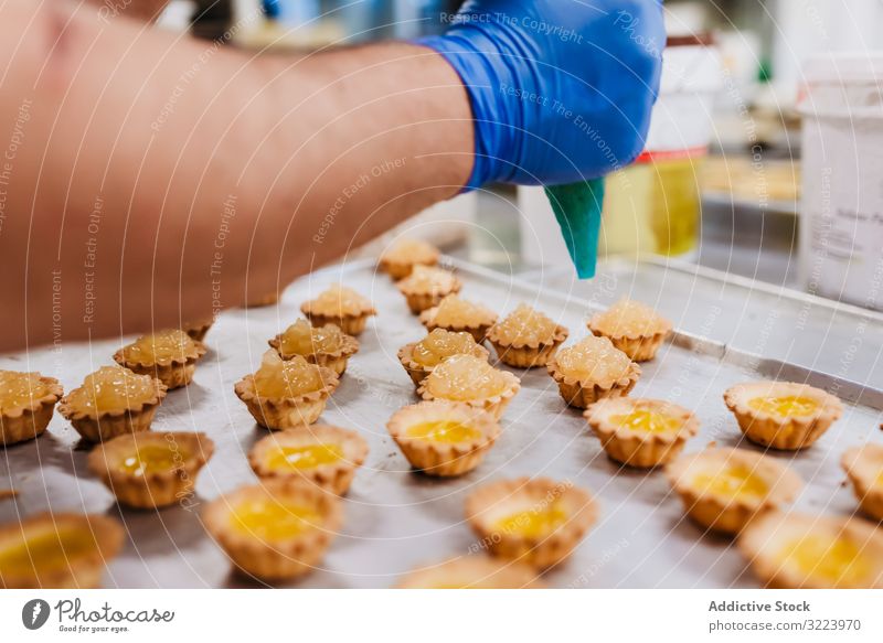 Erntebäcker, der Teig auf einem Blech auspresst Konditor Bäckerei Teigwaren drücken Tablett Keks Arbeit Küche Vorbereitung professionell Lebensmittel Papier