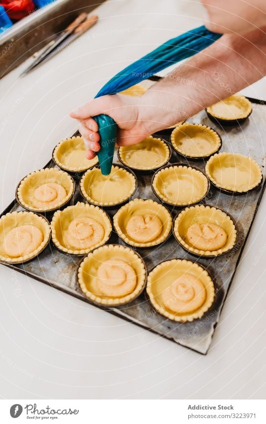 Erntebäcker, der Teig auf einem Blech auspresst Konditor Bäckerei Teigwaren drücken Tablett Keks Arbeit Küche Vorbereitung professionell Lebensmittel Papier