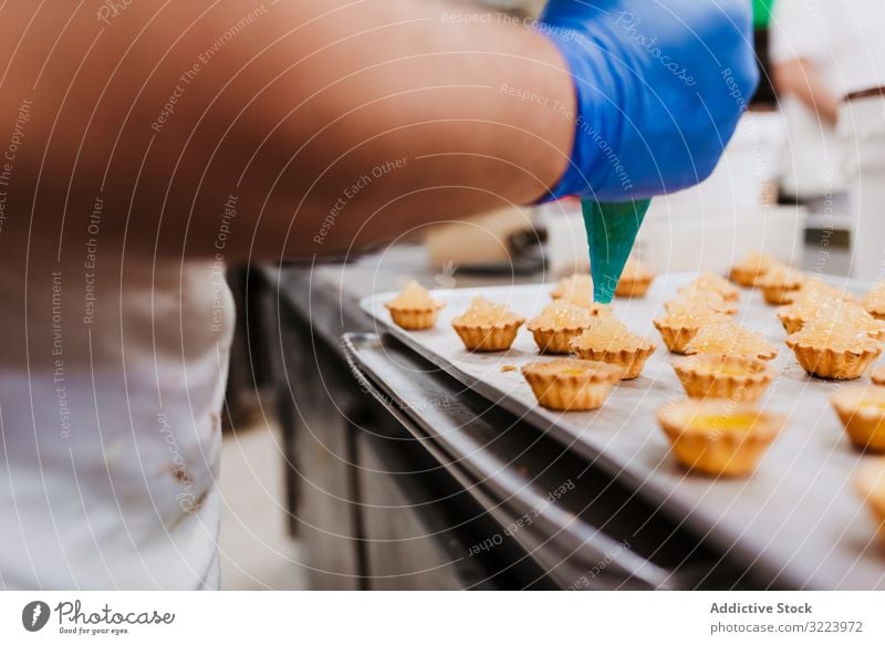 Erntebäcker, der Teig auf einem Blech auspresst Konditor Bäckerei Teigwaren drücken Tablett Keks Arbeit Küche Vorbereitung professionell Lebensmittel Papier