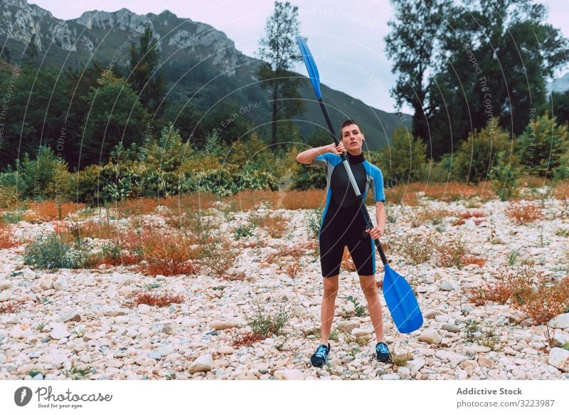 Weiblich stehend mit Paddel am Ufer Frau Training Sport Sella Fluss Spanien Kajakfahren üben Aktivität Lifestyle ernst konzentriert sportlich passen jung