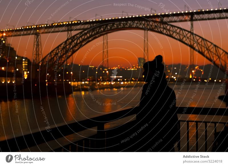 Frau geht bei Sonnenuntergang auf der Böschung Tourist Stauanlage Großstadt Brücke Fluss Borte Wasser Architektur Wahrzeichen Himmel wolkenlos Abend