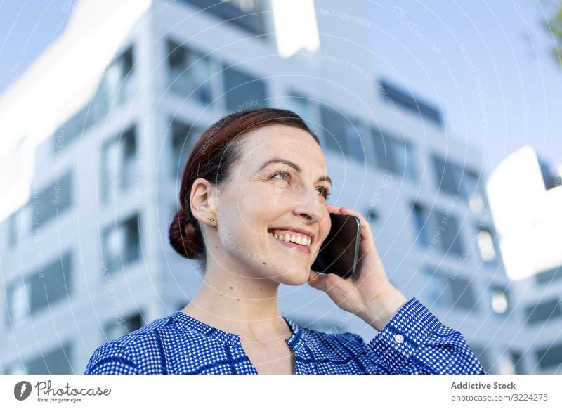 Seriöser Manager telefoniert auf der Straße Geschäftsfrau Smartphone reden ernst Stirnrunzeln Gebäude modern Großstadt urban Frau Mitteilung Arbeit Job Telefon