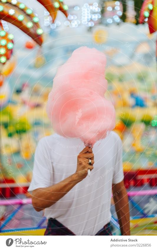 Zufriedener Mann genießt Zuckerwatte auf Kirmes Jahrmarkt essen genießen Spaß Hipster Vergnügen Park erfreut Inhalt Glück bärtig stehen Erwachsener Freude bunt