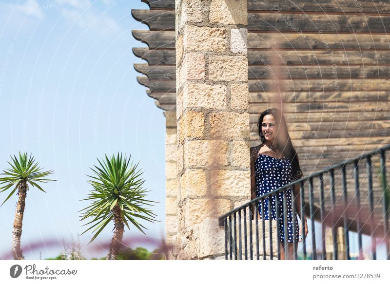 Schöne hispanische Frau in blauem Kleid, die sich an die Wand lehnt. Lifestyle Stil Glück schön Gesicht Sommer Mensch feminin Junge Frau Jugendliche Erwachsene