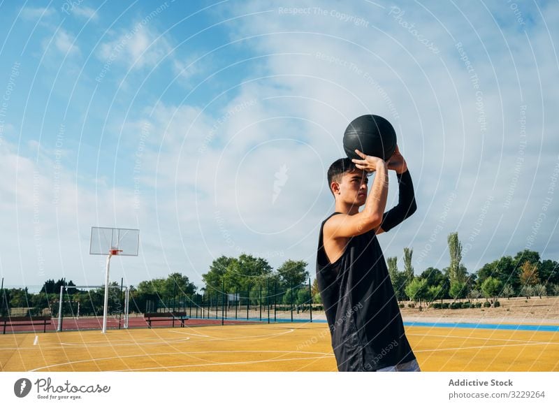 Junger Mann spielt auf einem Basketballplatz im Freien. Athlet Konkurrenz Sportgerät Erwachsener Erholung Aktion Ball Porträt aktiv Aktivität Asphalt sportlich