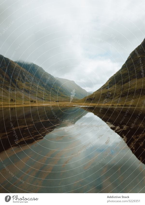 Ruhiger See inmitten von Hügeln an bewölktem Tag Natur Himmel wolkig Windstille Reflexion & Spiegelung Landschaft Großbritannien Wasser Teich friedlich ruhig