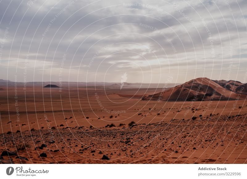 Sonnenuntergangshimmel über Hügeln in der Wüste wüst Sand Himmel wolkig Felsen trocken Marokko Afrika Abend niemand Landschaft Natur Düne Stein Felsbrocken