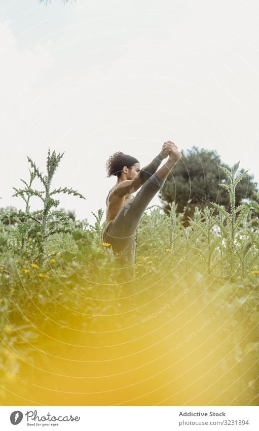 Mann trainiert Yoga auf der Wiese Asana Übung Energie Mediation Ausgeglichenheit Konzentration Dehnung Zen sich[Akk] entspannen Gleichgewicht Sport Lifestyle