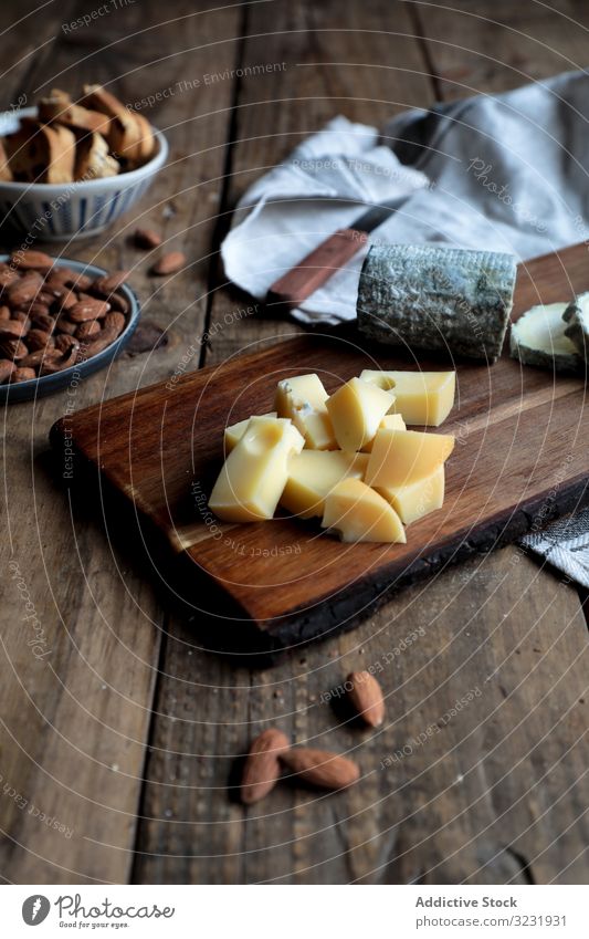 Croutons und Nüsse in Bretternähe mit Käse Holzplatte Tisch geschnitten Mandel Rosine Küche Lebensmittel hölzern Messer Brot Nut sortiert verschiedene Scheibe