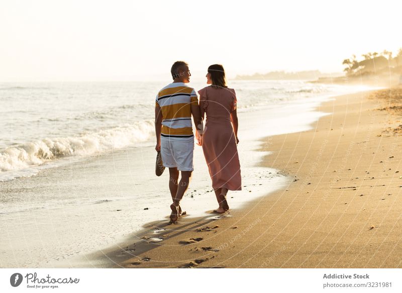 Erwachsenes Paar auf dem Weg zum Meer MEER Strand Spaziergang Sand winken Resort Zusammensein Händchenhalten Urlaub Mann Frau Erwachsener Barfuß Flitterwochen