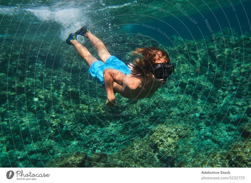 Männlicher Schwimmer schwimmt zwischen den Meereswellen Junge schwimmen unter Wasser MEER ruhig aktiv Oberfläche Training Windstille Sport Athlet Person stumm