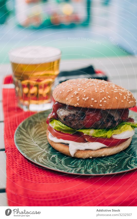 Cheeseburger mit Kopfsalat und Tomate Burger Brötchen klassisch ungesund Salat Tisch Lebensmittel Mahlzeit Zwiebel Rindfleisch lecker grillen Grillrost Snack