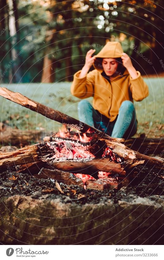 Reisende Frau wärmt Hände am Lagerfeuer auf Waldwiese warm ruhig Flamme nachdenken sich[Akk] entspannen Einsamkeit ruhen Windstille Stille Brennholz Freiheit