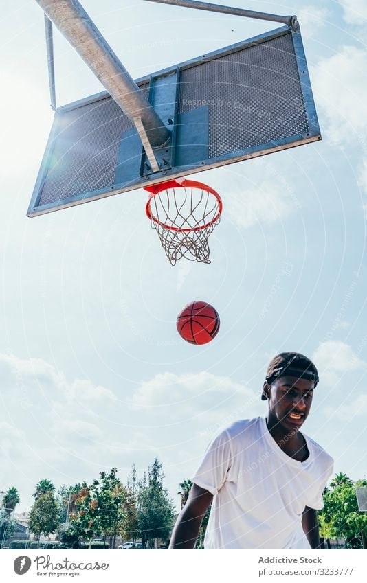 Afroamerikanischer Sportler nach Treffer im Basketball Ball tretend Netz Slam Dunk Runde Spiel Spieler Stadion Spielen Sportbekleidung Aktivität Feld männlich