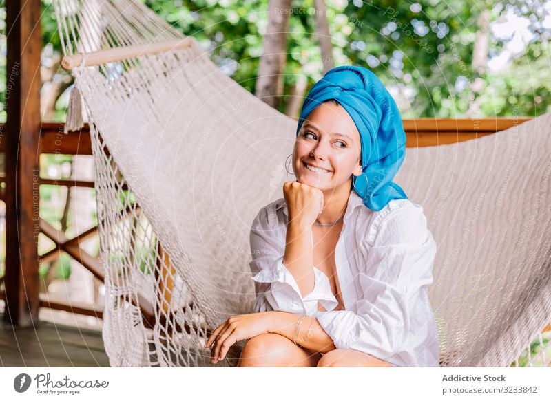 Frau mit Turban ruht sich in Hängematte aus ruhen Glück Lächeln berührendes Gesicht sitzen Terrasse Baum Grün Hemd friedlich Costa Rica jung