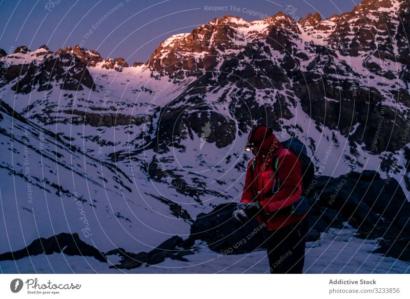 Bergsteiger mit Taschenlampe am Bergfelsen stehend Klippe Berge u. Gebirge ruhen hell Jacke Rucksack verschneite Marokko Toubkal Afrika malerisch Gipfel