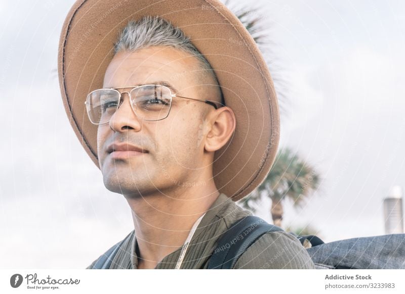 Junger Mann drückt seine Freude aus und posiert für ein Foto mit Brille und einem braunen ha Hut Erwachsener Spaß männlich Gesicht Lifestyle Menschen Muskel