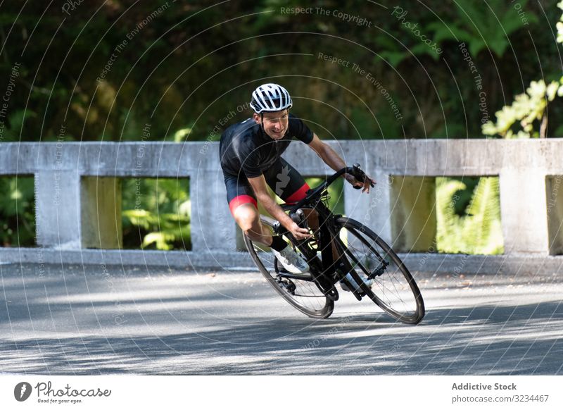 Profi-Radfahrer fährt Fahrrad im Park Mitfahrgelegenheit Sportler Rennen professionell Weg sonnig tagsüber männlich Sicherheit Schutz Schutzhelm Schutzbrille