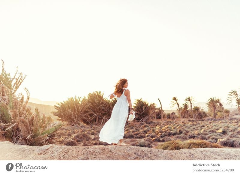 Frau in weißem Kleid auf trockenem Feld im Sonnenlicht stylisch laufen trocknen Licht Landschaft Natur Sommer Schönheit Tag schön natürlich genießend romantisch