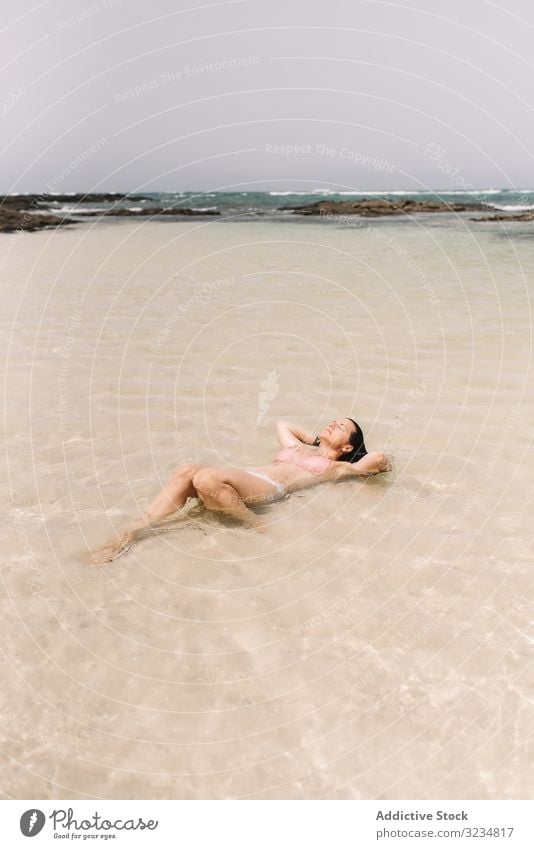 Frau im Badeanzug am Meeresufer im Wasser liegend Seeküste Schwimmsport Sommer MEER Strand Freizeit schön Urlaub Ufer Badebekleidung Küste fliegend heiter