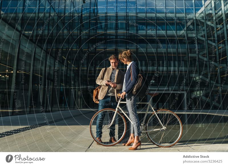 Geschäftsleute im Gespräch auf der Straße nach der Arbeit reden Lächeln Gebäude Fahrrad Mann Frau Kollege Zusammensein Paar Büro lässig Business Großstadt Stadt