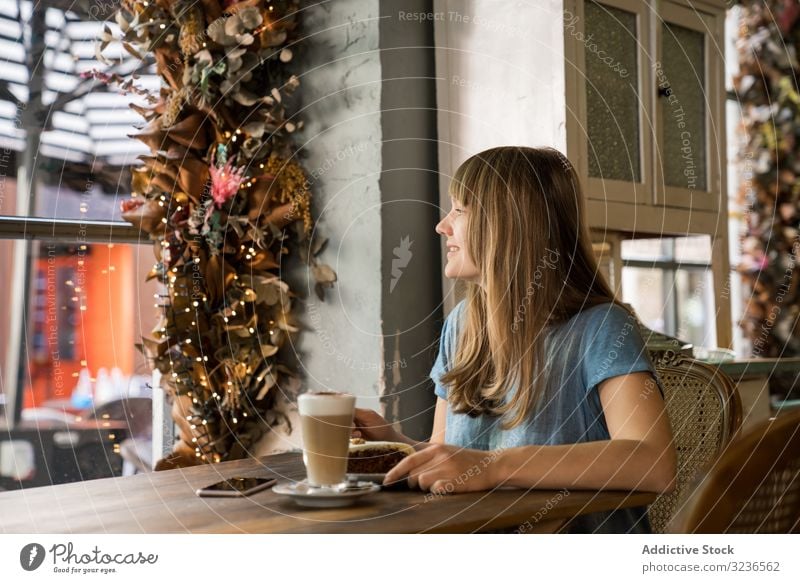 Fröhliche Frau benutzt Telefon im Café Smartphone Kaffee Lifestyle jung Mobile Glück heiter Lächeln Lachen Freizeit trinken lässig Restaurant Sitzen Halt