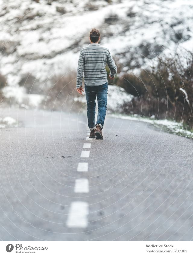 Mann zu Fuß auf der Landstraße Straße wolkig trist Schnee Hügel Spaziergang Wald männlich neblig Erwachsener allein Baum gefroren kalt Natur Erholung ruhen