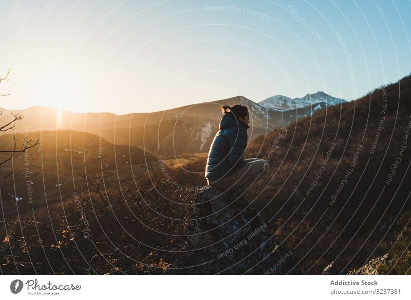 Weibliche Reisende sitzt bei Sonnenuntergang am Berghang Frau Berge u. Gebirge Herbst Top sitzen Erholung genießen jung friedlich nachdenklich Freiheit Himmel