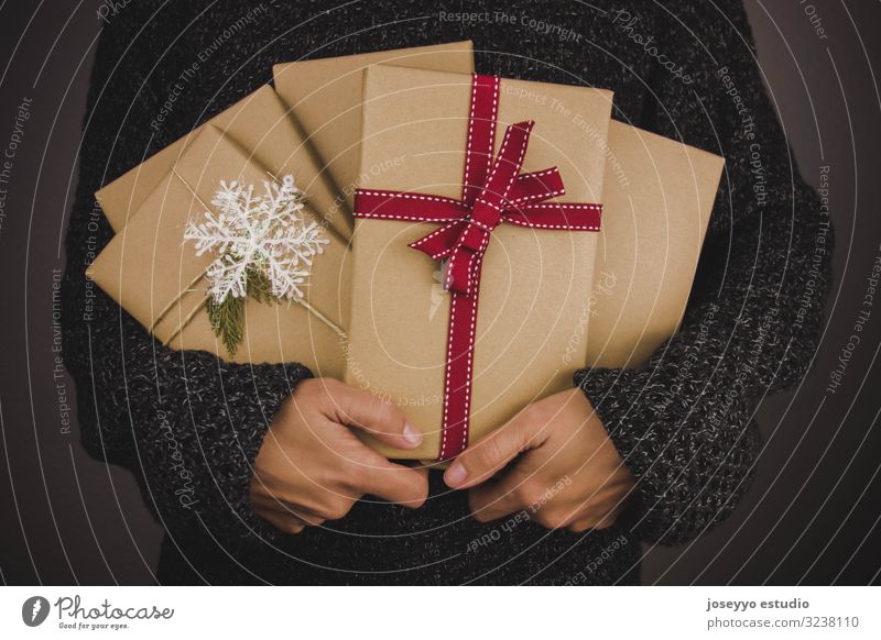 Frau mit dunklem Pullover, die viele Weihnachtsgeschenke hält. schwarz Buch Kasten Weihnachten & Advent Claus Zusammensetzung Handwerk dunkel festlich Tanne