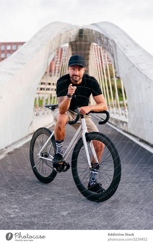 Fröhlicher Mann mit Fahrrad auf Steg stehend Großstadt Mitfahrgelegenheit Brücke modern aktiv sportlich Sommer männlich Erwachsener Glück heiter Lächeln