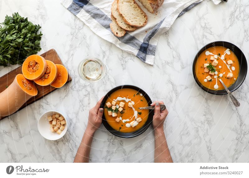 Personenhände halten Schüssel mit Karottensuppe Sahne Lebensmittel Schalen & Schüsseln Diät Gesundheit Gemüse Kürbis Suppe orange abgestimmt Küche Teller frisch