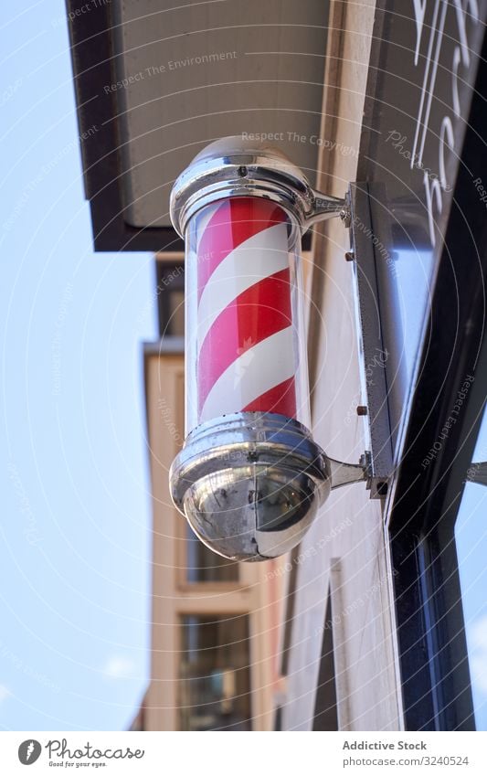 Vertikales Foto eines sich drehenden Pfostens, der den Friseurladen an der Fassade symbolisiert rotierend Symbol signalisieren Barbershop Straße Beitrag Farbe