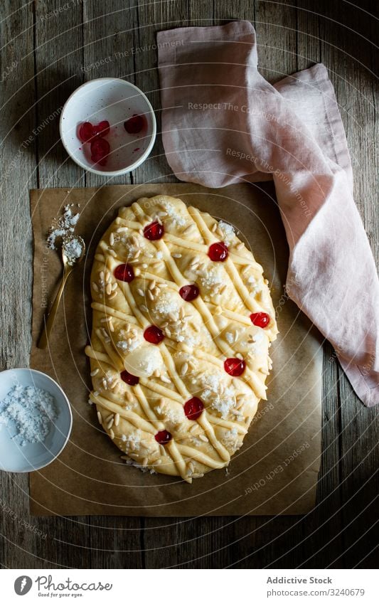 Coca de San Juan auf rustikalem Tisch Gebäck traditionell frisch coca de san juan Buch Rezept Messer Handtuch Samen Lebensmittel selbstgemacht Bäckerei Dessert