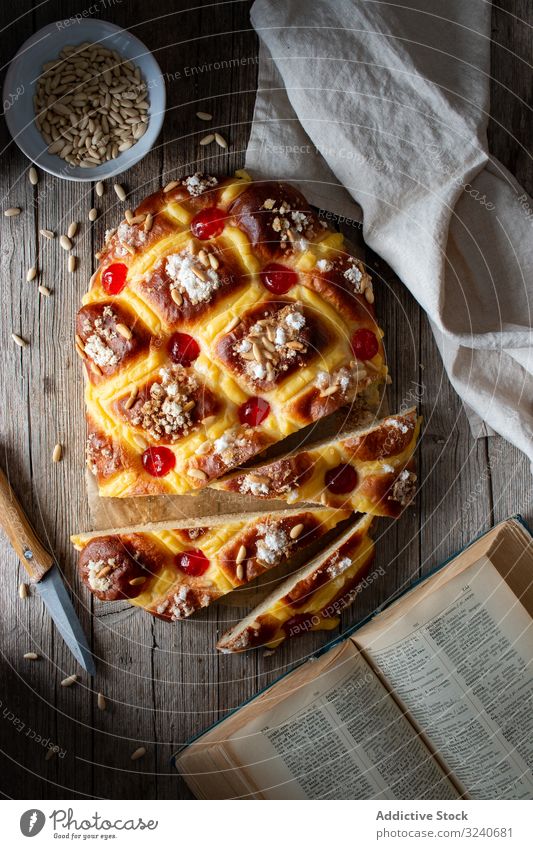 Coca de San Juan auf rustikalem Tisch Gebäck traditionell frisch coca de san juan Buch Rezept Messer Handtuch Samen Lebensmittel selbstgemacht Bäckerei Dessert